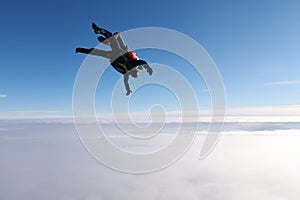 Skydiving. A tandem jump is in the cloudy sky.