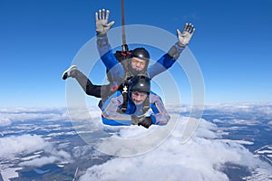 Tandem skydiving. Two guys are in the blue sky. photo