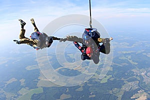 Skydiving. Tandem and sportsman are gripping hands in the sky.
