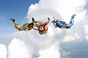 Skydiving. Two instructors are training a student to fly.