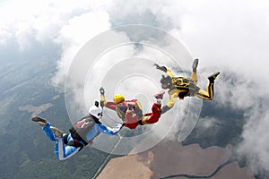 Skydiving. Two instructors are training a student to fly.