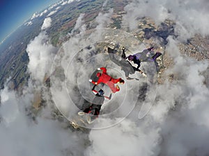 Skydiving 4 way team above the clouds.