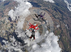 Skydiving 4 way team above the clouds.