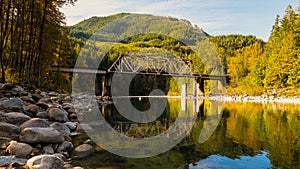 Skykomish River reflecting the railway bridge as the trees begin to turn fall colors