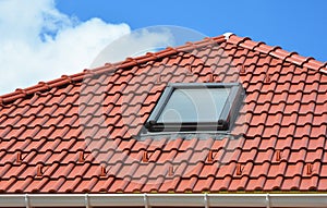 Skylight on red ceramic roof tiles house roof. Modern Roof Skylight. Attic Skylights Home Design. Roofing Construction.