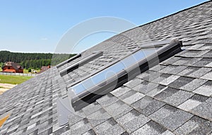 Skylights windows on modern house roof top.  Attic skylight windows on asphalt shingles roof