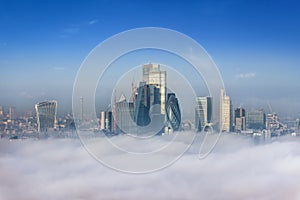 The skyline of the City of London peaking out of the fog photo