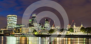 Skyline of the City of London and the Tower of London at night, in London, England, UK