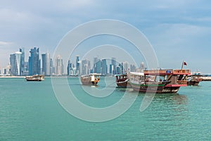 The skyline of Doha, Qatar with traditional dhows in the foreground.