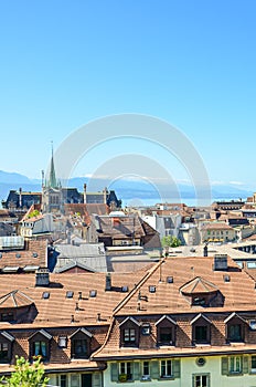 Skyline of Lausanne, Switzerland photographed from view point above the Swiss city. Lake Geneva and mountain peaks in the