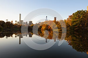 Skyline of Manhattan reflected in a pond in central park at sunrise