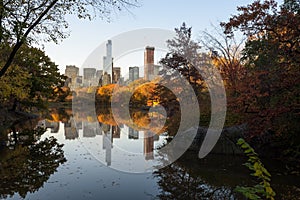 Skyline of Manhattan reflected in a pond in central park at sunrise