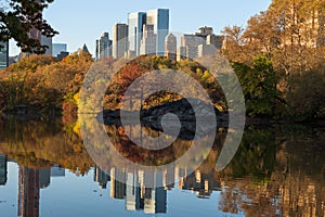 Skyline of Manhattan reflected in a pond in central park at sunrise