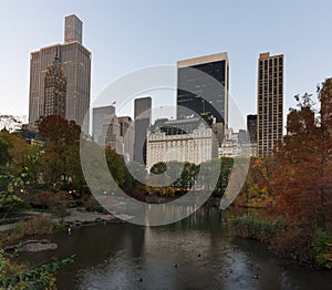 Skyline of Manhattan reflected in a pond in central park at sunrise