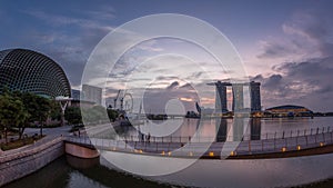 Skyline in Marina Bay with Esplanade Theaters on the Bay and Esplanade footbridge night to day timelapse in Singapore.