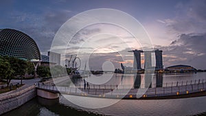 Skyline in Marina Bay with Esplanade Theaters on the Bay and Esplanade footbridge night to day timelapse in Singapore.