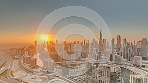 Skyline with modern architecture of Dubai business bay towers at sunset timelapse. Aerial view