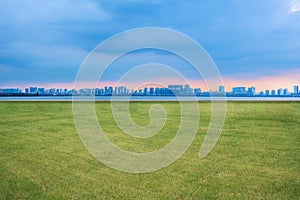 The skyline of modern urban architecture and the scenery of park lawn in Suzhou, Jiangsu Province, China