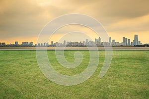 The skyline of modern urban architecture and the scenery of park lawn in Suzhou, Jiangsu Province, China