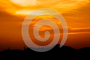 The skyline of the mountains and the oil production industry There is an orange-red light during the sunset. silhouette industrial