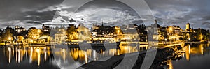 Skyline at night of Murten in Switzerland with the harbor and pier and boat in the foreground