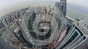 Skyline panorama of Dubai Marina showing canal surrounded by skyscrapers along shoreline night to day timelapse. DUBAI