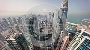 Skyline panoramic view of Dubai Marina showing an artificial canal surrounded by skyscrapers along shoreline timelapse