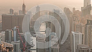 Skyline panoramic view of Dubai Marina showing an artificial canal surrounded by skyscrapers along shoreline timelapse