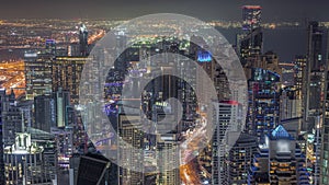 Skyline panoramic view of Dubai Marina showing canal surrounded by skyscrapers along shoreline night timelapse. DUBAI