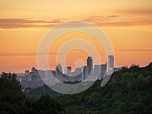 Skyline shot of Austin Texas downtown nestled between hills during vibrant golden sunrise