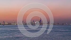 Skyline with Skyscrapers day to night timelapse in Kuwait City downtown illuminated at dusk. Kuwait City, Middle East