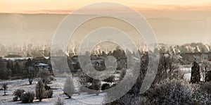 Skyline of small village in winter with fuming chimneys