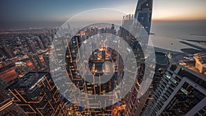 Skyline sunset view of Dubai Marina showing canal surrounded by skyscrapers along shoreline day to night timelapse