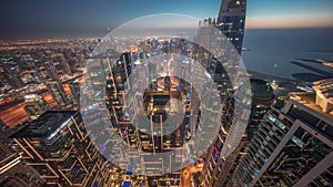 Skyline sunset view of Dubai Marina showing canal surrounded by skyscrapers along shoreline day to night timelapse