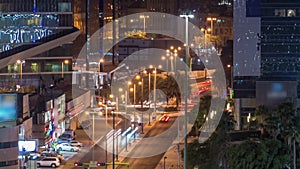 Skyline and traffic on crossroad night timelapse in Kuwait City downtown illuminated at dusk. Kuwait City, Middle East