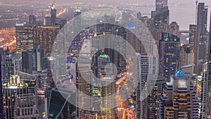 Skyline view of Dubai Marina showing canal surrounded by skyscrapers along shoreline day to night . DUBAI, UAE