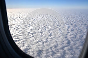 Skyscape with cloud from the plane window. Airplane wing on beautiful blue sky with cloud background