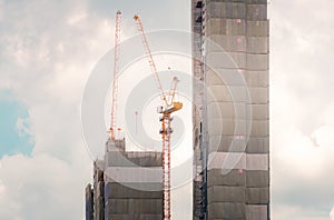 Skyscraper building construction. Crane working in construction site. Property and real estate development industry. Apartment