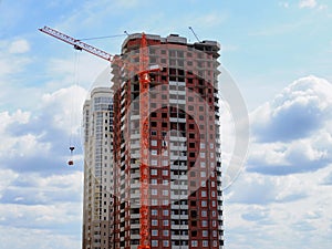 Skyscraper construction. Construction site background. Self-erecting crane with cargo near the building under construction