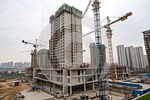 Skyscraper construction with tower crane on housing site photo