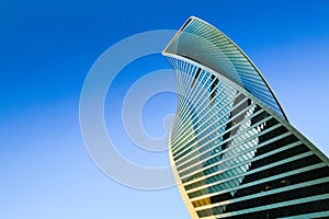 Skyscraper exterior. Modern office building, glass facade in blue sky. Urban view, looking up city, skyline.