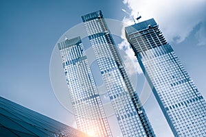 Skyscraper glass facades on a bright sunny day with sunbeams in the blue sky. Economy, finances, business activity concept. Bottom