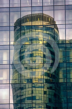 Skyscraper of glass and metal is reflected in the mirror wall of another