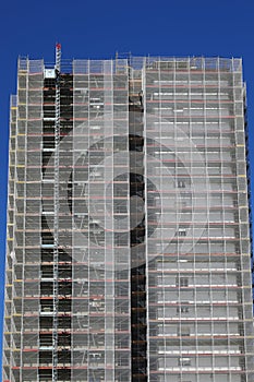 skyscraper during maintenance and installation of insulation panels to safeguard the environment photo