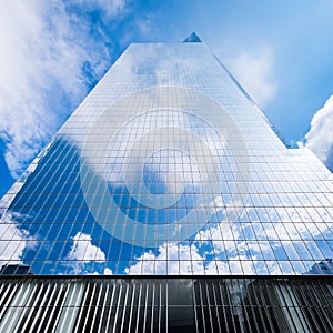 Skyscraper reflecting blue sky and white clouds