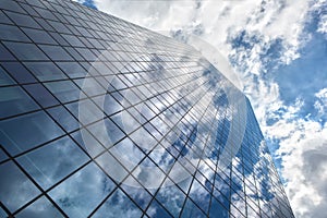 Skyscraper with reflection of blue sky and clouds