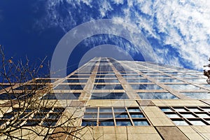 Skyscraper On A Sunny Day With Blue Skies And Clouds In The Background