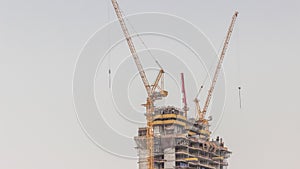 Skyscraper under construction with cranes and iron frame timelapse