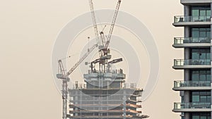 Skyscraper under construction with cranes and iron frame timelapse