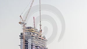 Skyscraper under construction with cranes and iron frame timelapse